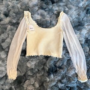 Cute, cream colored, sheer sleeved, textured center, cropped top.